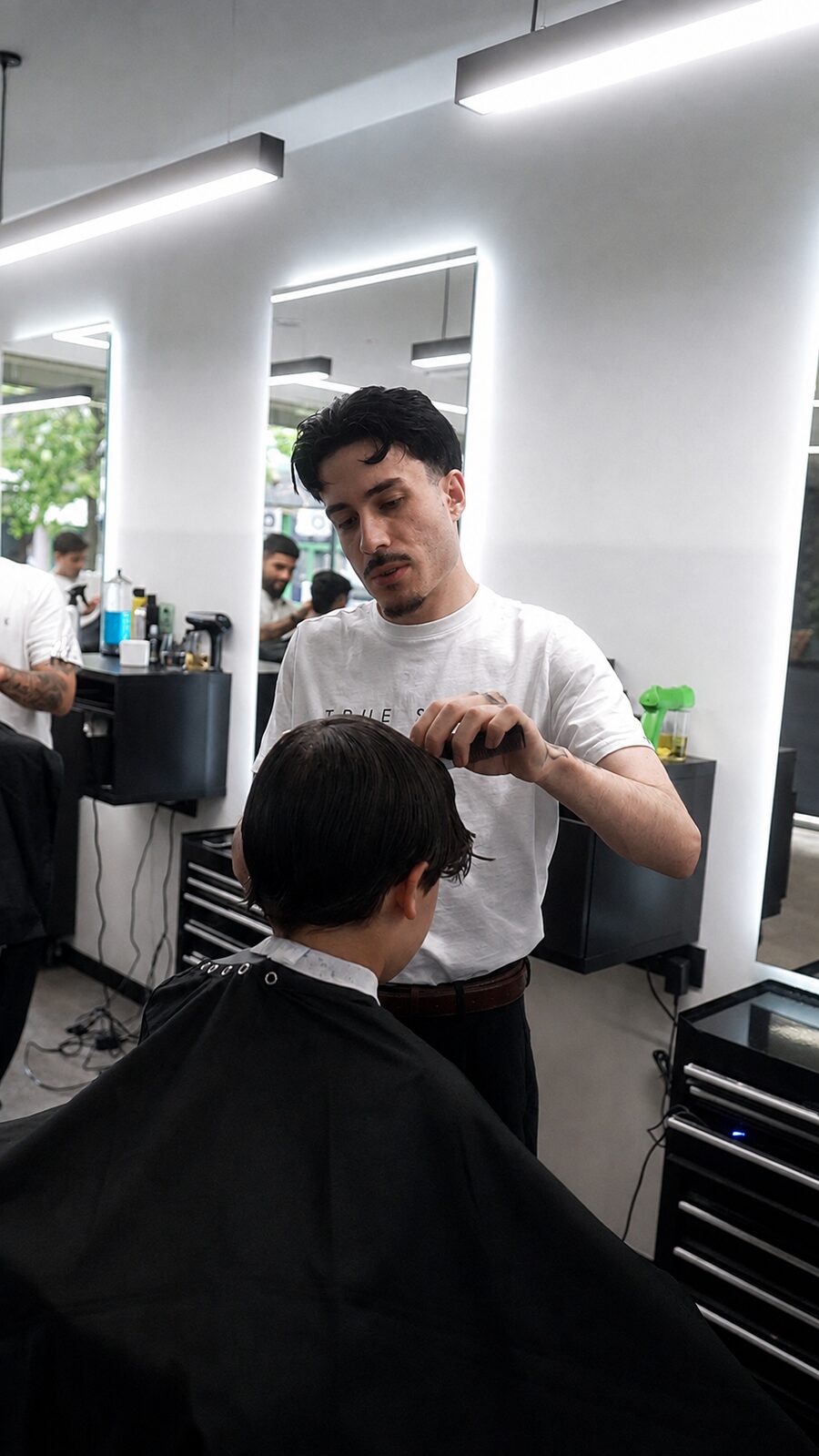 Barbeiro a pentear o cabelo de um cliente